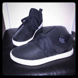 Black sneakers with white soles.